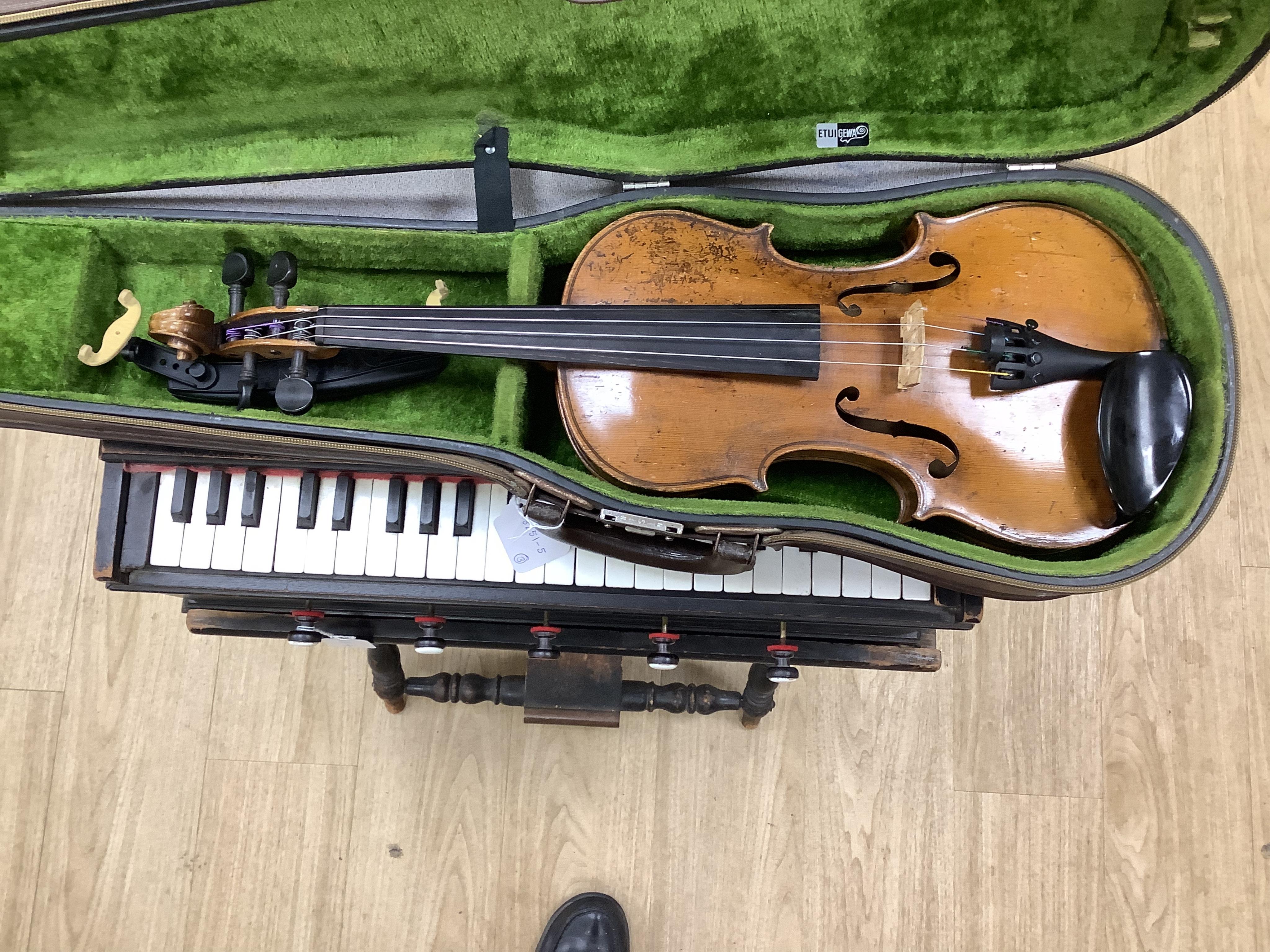 A cased 7/8 size 19th century violin, body 35cm, together with another cased violin, body 35.5cm, both without bows, and a spare case (3)